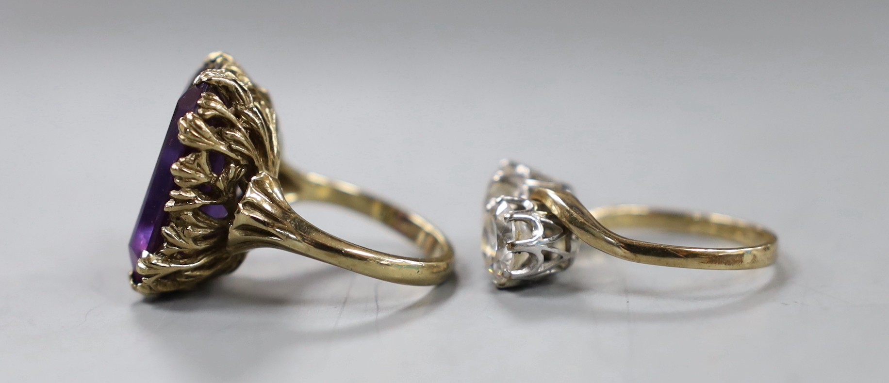 A modern 9ct gold and two stone simulated diamond set crossover ring, size Q and a yellow metal and synthetic colour change corundum set dress ring, gross weight 16.2 grams.